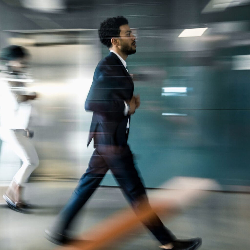 A man walking quickly in a hall.