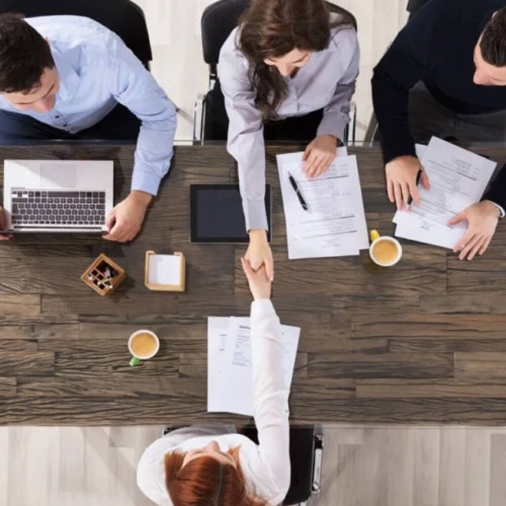 People working across a table on their laptops.