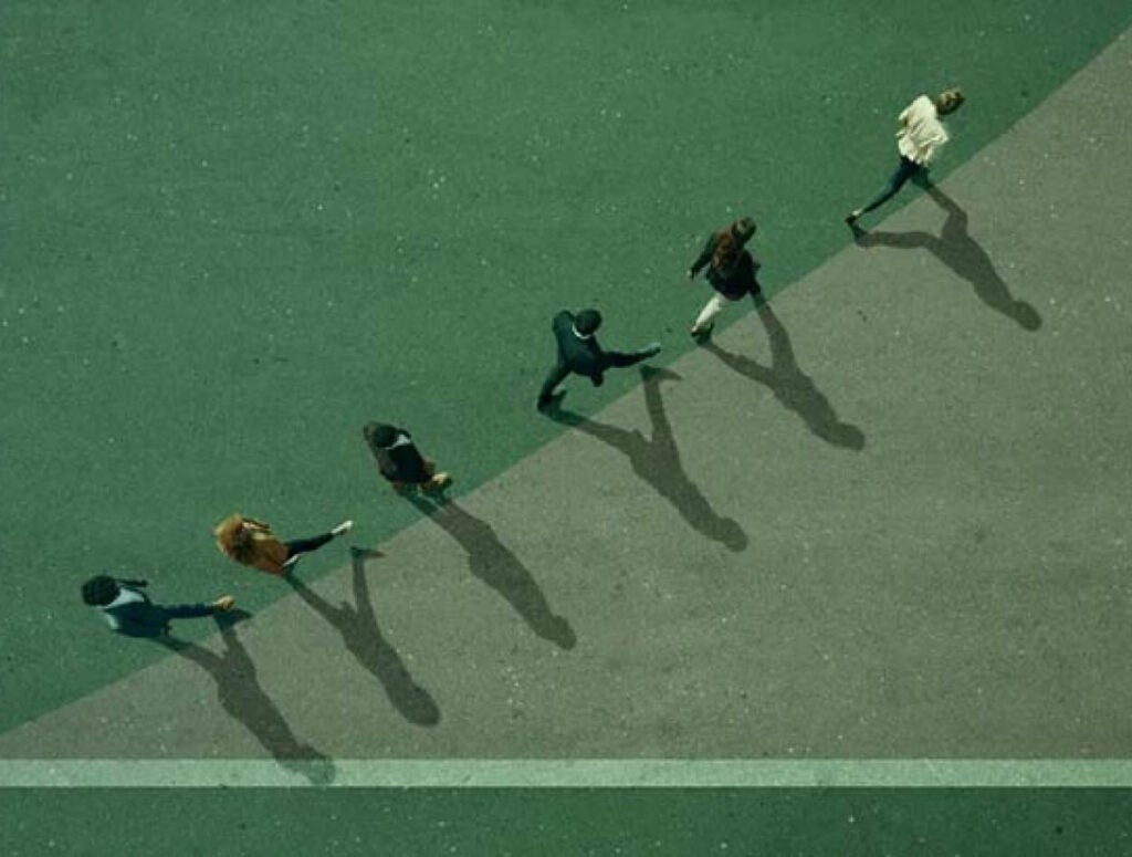 Bird's eye view of people walking in a curved line upwards.