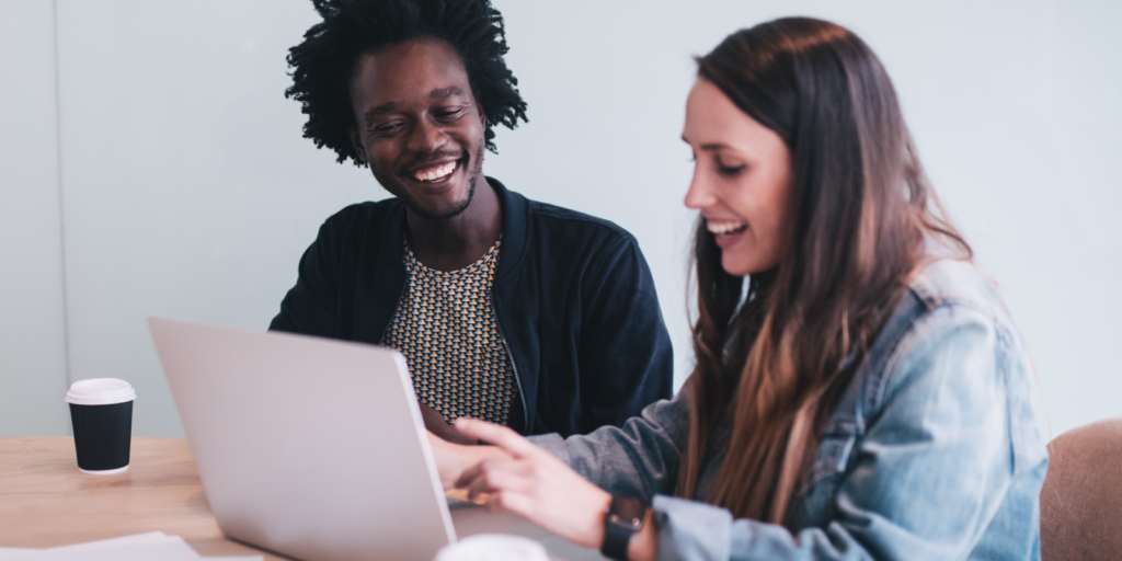 Photo of man and woman looking at laptop